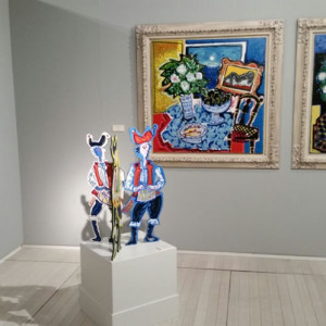 La escultura Gaiteiros, con Atardecer en Cela y Concierto en el salón, al fondo