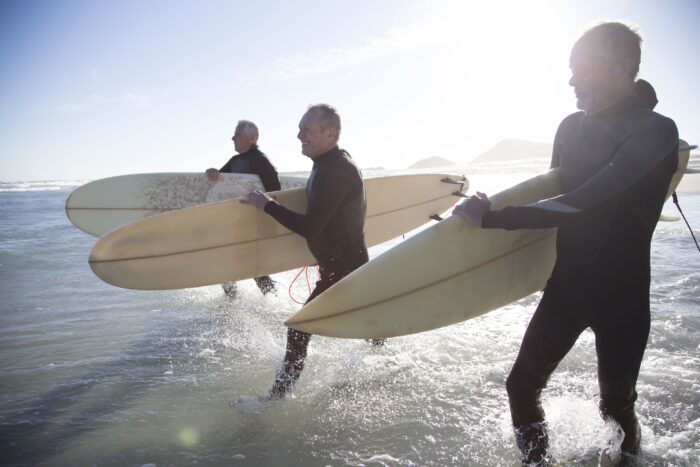 senior-surfers-on-a-beach-at-sunset-royalty-free-image-666740911-1544697593